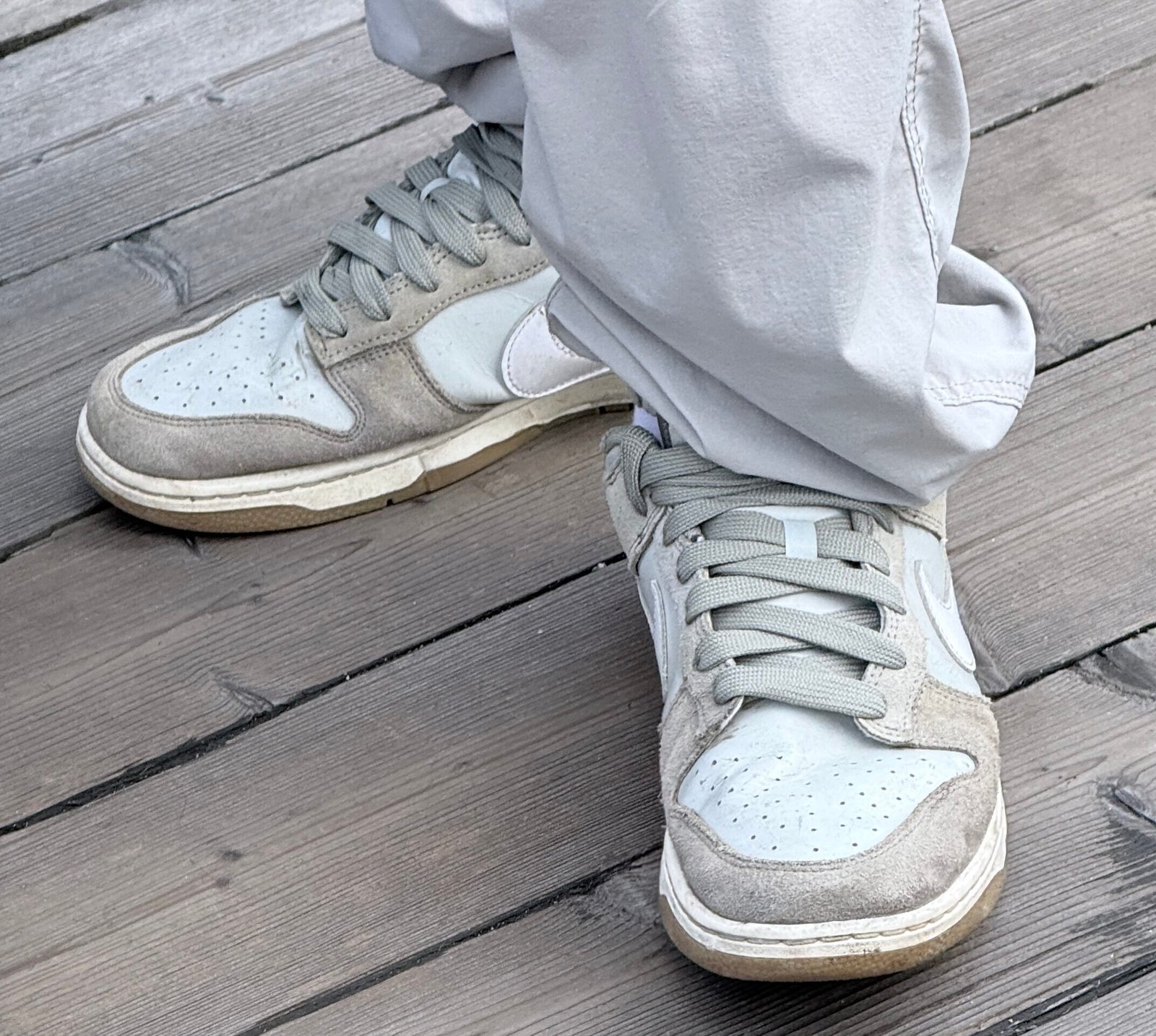 A pair of nike shoes with what and grey and light blue parts.